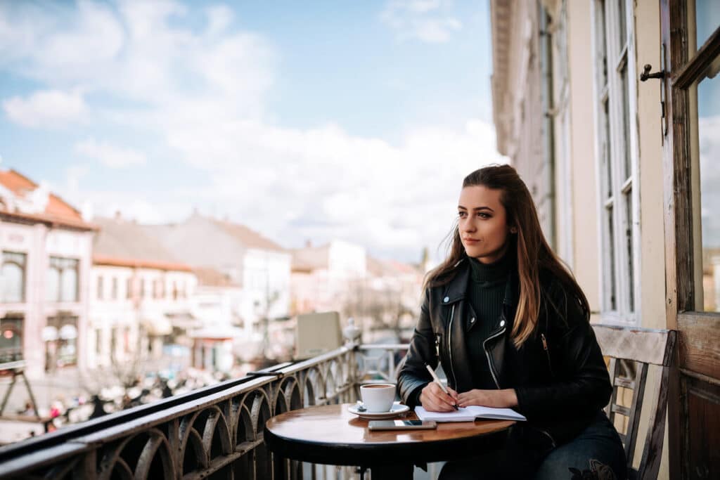 Lovely girl studying outdoors in the cafe.